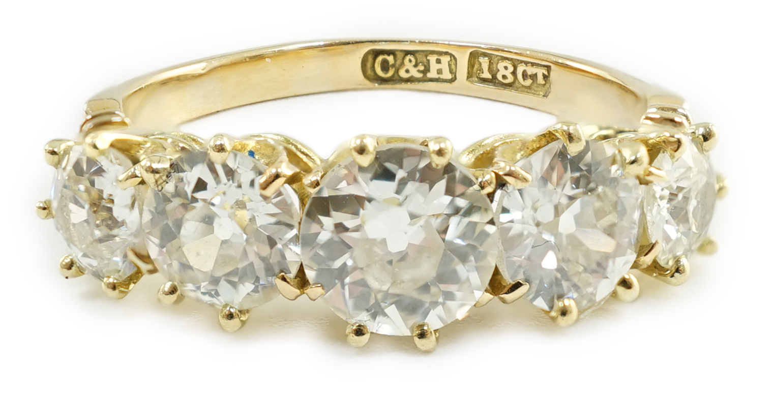 An 18ct gold and graduated five stone diamond set half hoop ring